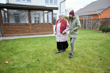Outdoor walk: bonding moment between two family members in backyard garden