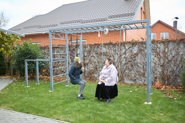 Outdoor gym chat: senior and young person exercise and connect in the backyard