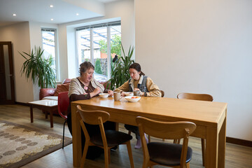 Family time at home: relaxed conversation over breakfast in modern dining room