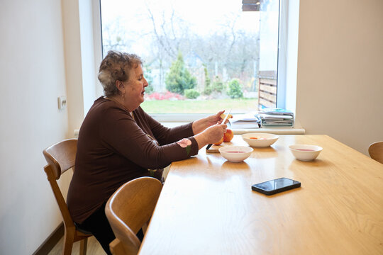Elderly woman enjoying breakfast in cozy kitchen setting