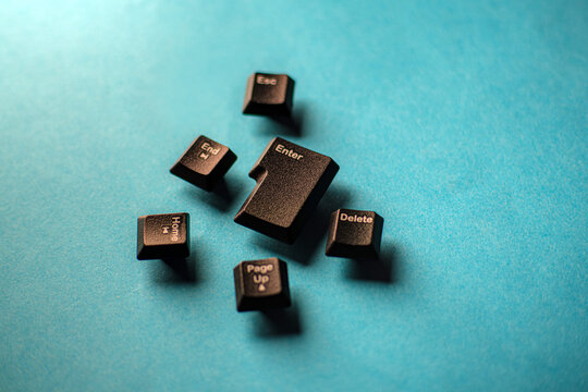 Scattered black keyboard function keys like Enter, Delete, and Home rest on a bright aqua blue background. Symbolizing hardware failure and technology concepts. Great for coding websites.