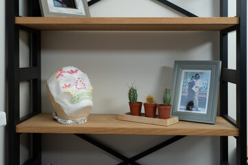 Decorative shelf scene with framed photo, sugar skull and small cacti, creating a warm, personal home atmosphere.