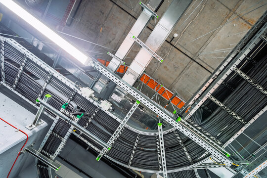Close-up of industrial electrical installations and cable trays. Intricate network of power cables and wires for industrial or commercial infrastructure.