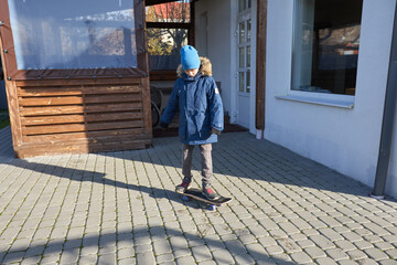 Child enjoying skateboard ride in winter backyard