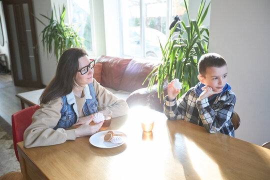 Mother and son enjoying afternoon snack together at home