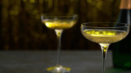 Champagne bottle and glasses on a table, on golden bokeh background.
two glasses of champagne and champagne bottle on a table.  Party and holiday celebration concept.