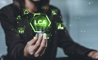 Woman holding glowing lightbulb with LCA text and sustainability icons representing life cycle assessment on eco-friendly green tech concept background.