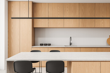 Modern minimalist kitchen interior design with light wooden cabinets, matte chairs, and concrete countertops in soft natural lighting. 3D Rendering