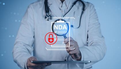 Doctor holding tablet with NDA confidentiality document and health padlock icon hologram on blue background, medical data privacy concept..