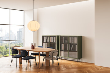 Modern dining room interior with wooden table, stylish chairs, hanging light and green cabinets in bright apartment with city view window. 3D Rendering