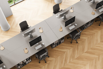 Obraz premium Top view of modern office interior with shared workstations, wooden floor, and minimalist design aesthetic in a bright workspace setting. 3D Rendering