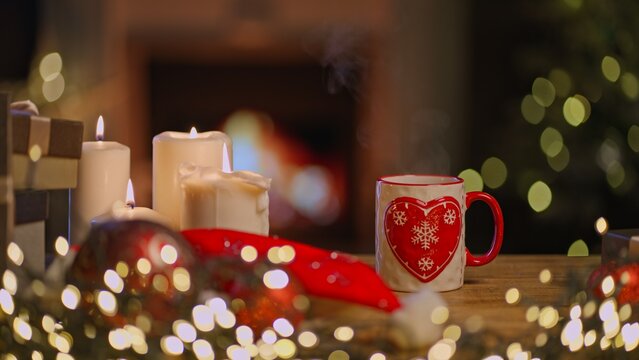 Still life of Christmas decoration and candle at home in cosy living room with fireplace. Winter holiday mood.
