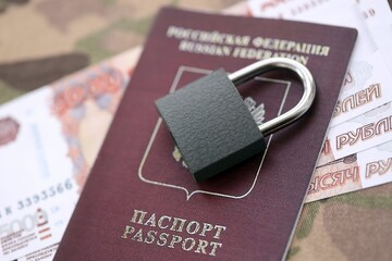 Russian rubles money bills and passport under ban of heavy lockpad close up. Concept of sanctions...