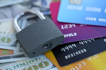 One hundred US dollar bill banknotes and credit cards with padlock. Concept of security and safe banking