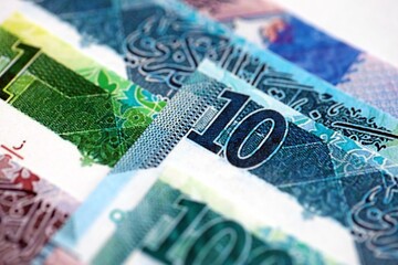 Qatari riyal money bills banknotes lies in big pile on table close up. Concept of finances and...