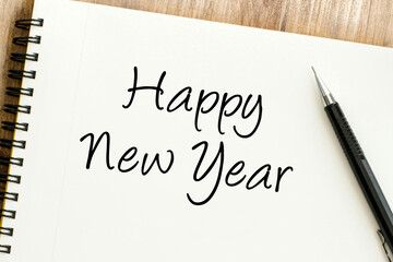 Happy New Year greeting penned on a clean notebook page, symbolizing fresh starts and future aspirations