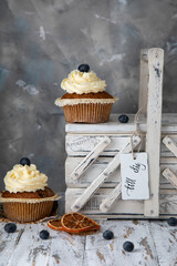 Homemade cupcakes with buttercream frosting and a white vintage box with a name tag that reads "For You."