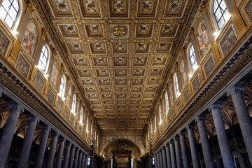 Fototapeta premium Ornate gilded coffered ceiling and luminous mosaics decorate the majestic nave of Santa Maria Maggiore Basilica.