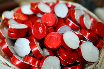 Basket filled with red‑rimmed votive tealights, ready for offerings and prayers in the sanctuary..