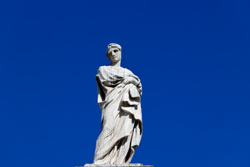 St. Peter&rsquo;s Basilica. Single stone figure stands above Vatican fa&ccedil;ade, folded arms, classical drapery, serene expression.