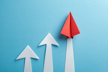 Red paper airplane atop ascending white arrows