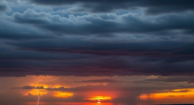 Dramatic sunset over water with dark storm clouds and a lightning strike