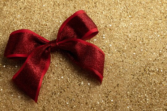 Hand drawn Christmas background photo featuring a sumptuous red velvet ribbon bow elegantly tied around a gift or evergreen sprig, with soft holiday lighting and a warm festred bow on a red background - Powered by Adobe