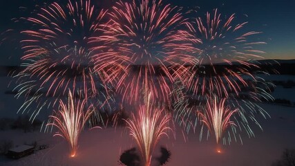 Aerial view of colorful fireworks exploding over a snowy winter landscape at night - Powered by Adobe