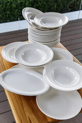 Set of white clean dishes and plates on the table