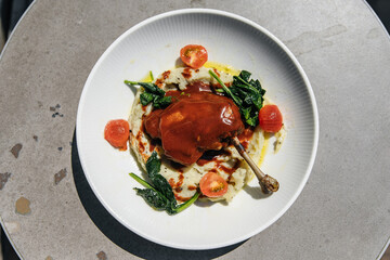 Duck leg with mashed vegetables and sauce on the table in a bowl