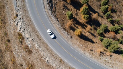 White Car Driving On A Winding Mountain Road Surrounded By Autumn Foliage. Scenic Journey Through Nature