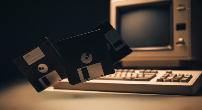 A nostalgic glimpse into the past, featuring a vintage computer and floppy disks, a symbol of information. It evokes a sense of retro tech nostalgia and a simpler era of computing.