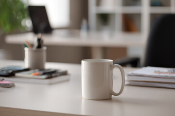Obraz premium White ceramic mug on modern work desk with blurred office background, natural light, and organized stationery, creating calm and productive workspace atmosphere