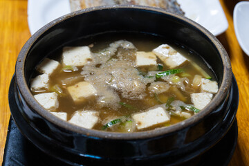 hot doenjang jjigye in a black ceramic bowl. A Korean cuisine