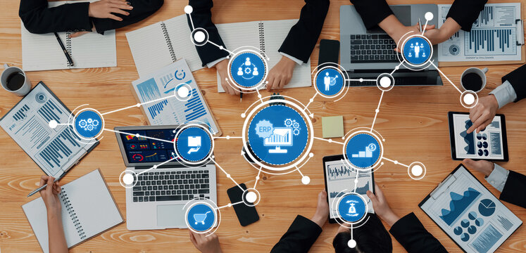 A dynamic business meeting showcasing teamwork with data analysis tools and ERP system visualization, promoting effective communication and strategic planning efforts. Amity - Powered by Adobe