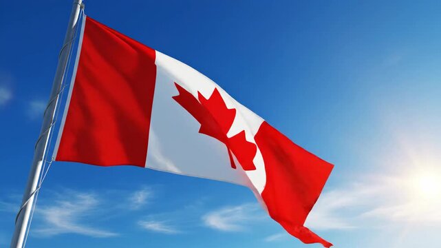 A Canadian flag waving on a silver pole, set against a clear blue sky with wispy clouds and sunlight