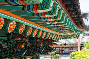 colorful wooden eaves and a hanging electric lamp at the Buddhist temple building