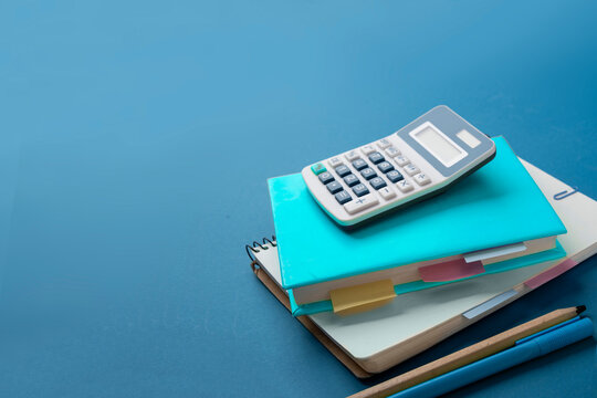 Calculator, textbook, notepad with bookmarks and stickers. The concept of diligent study of mathematics, physics and economics