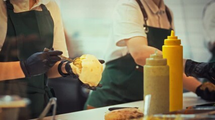 Chefs in aprons and gloves quickly prepare fresh pita snacks at a busy outdoor market. The air is filled with the enticing aroma of grilled ingredients, attracting hungry customers