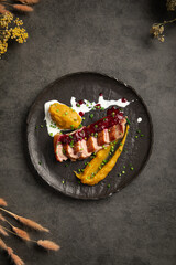 Tender seared duck fillet served with smooth pumpkin puree rich berry sauce and fresh herbs