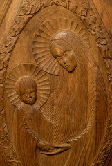 Wood sculpture (19th century) of Blessed Virgin Mary holding baby Jesus Christ in her arms.