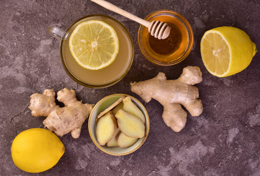 Ginger tea with honey and lemon on a gray background. Flat lay.