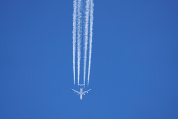vierstrahliges Flugzeug mit Kondensstreifen
