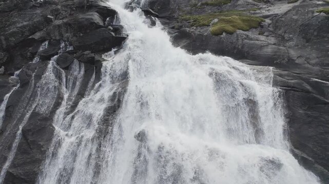 Dramatic close-up waterfall reveal in Rago National Park, Norway &ndash; rugged rocks, flowing water and misty atmosphere