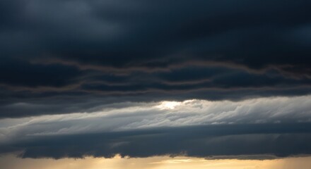 Obraz premium Dramatic storm clouds gathering above the horizon at sunset create a moody atmosphere with a