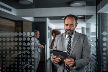 Senior businessman working on tablet in modern office