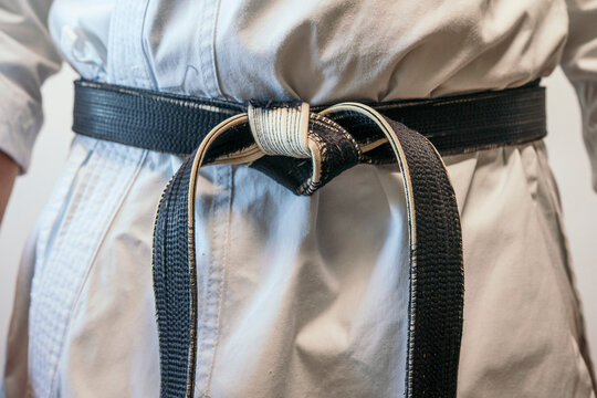 Close-up of tied black martial arts belt.