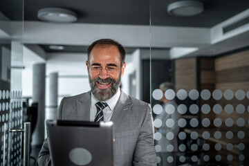 Senior businessman smiling enjoying working with digital tablet