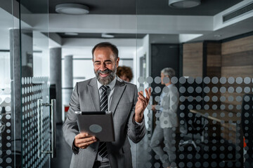 Mature businessman doing video call using digital tablet in office