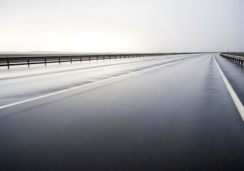 Reflective expanse of wet highway asphalt on a day with overcast sky